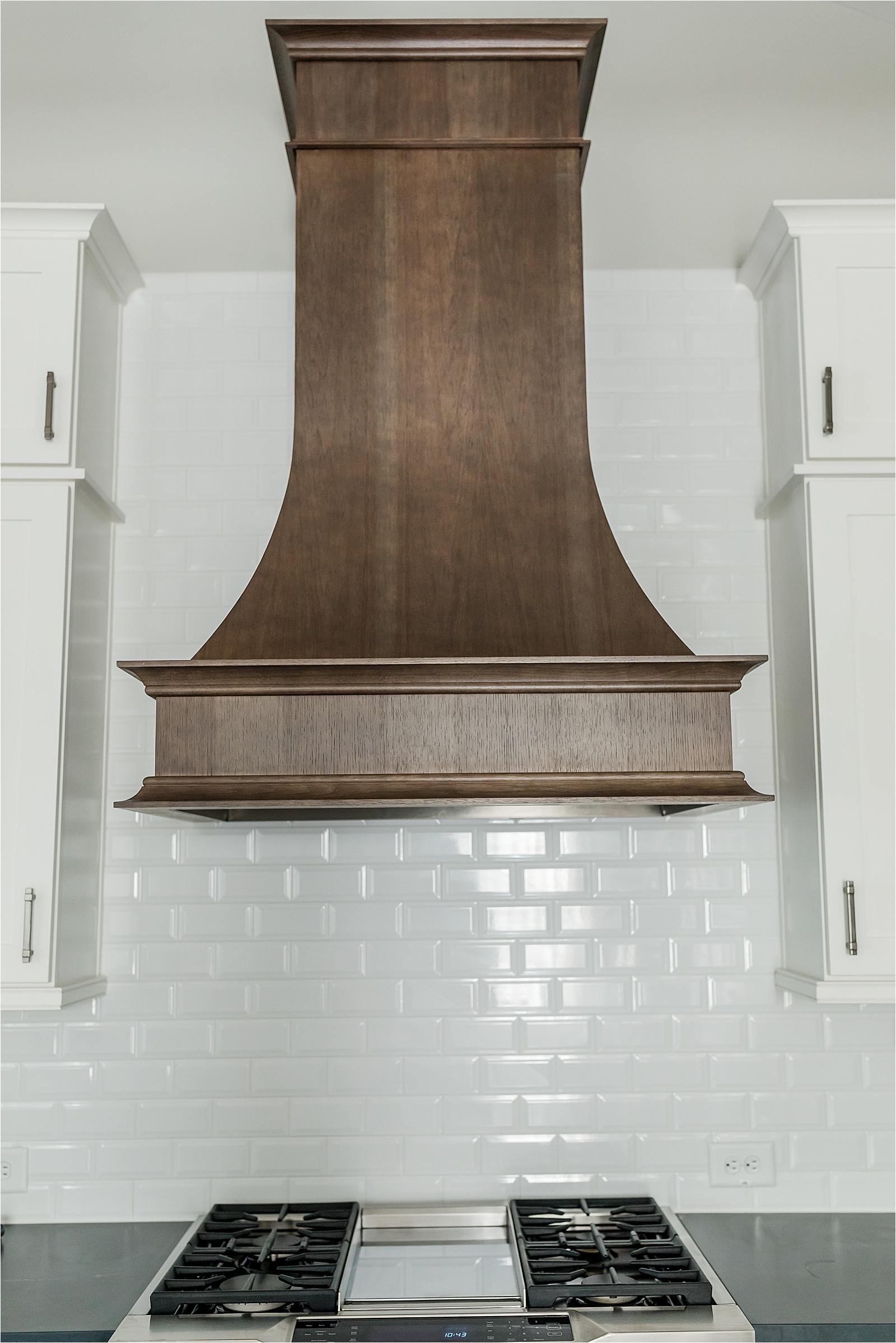 wood accent hood with white subway tile