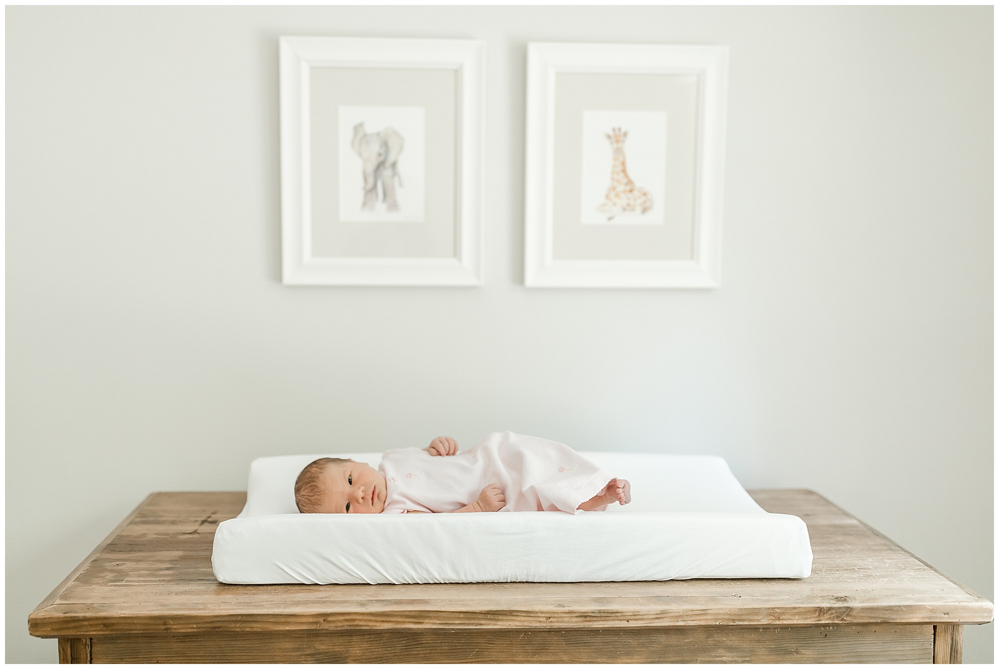 Portrait of a newborn baby girl laying on her changing table
