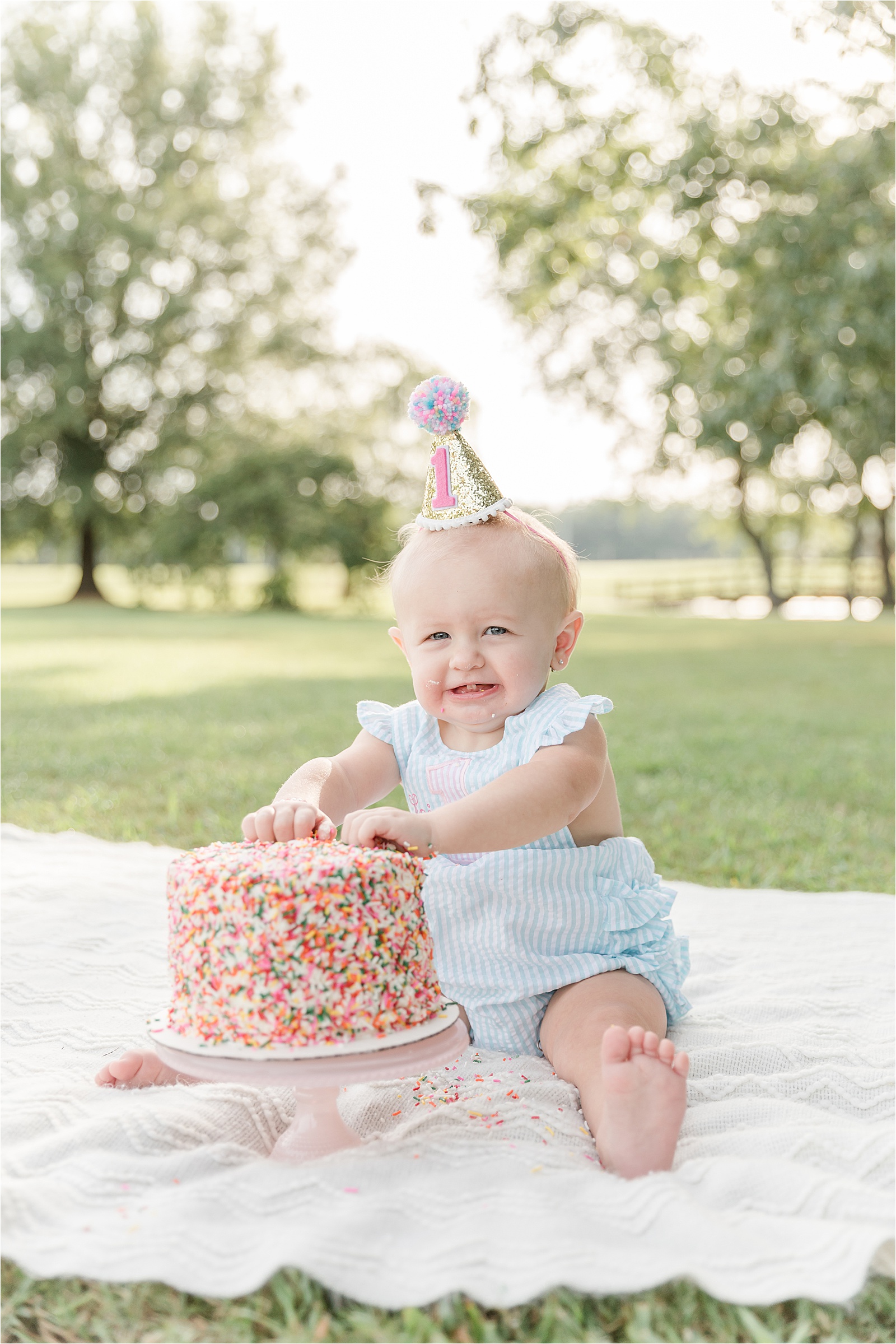 Baby girl with sprinkle cake and sequined birthday hat by photographer in Greenville SC