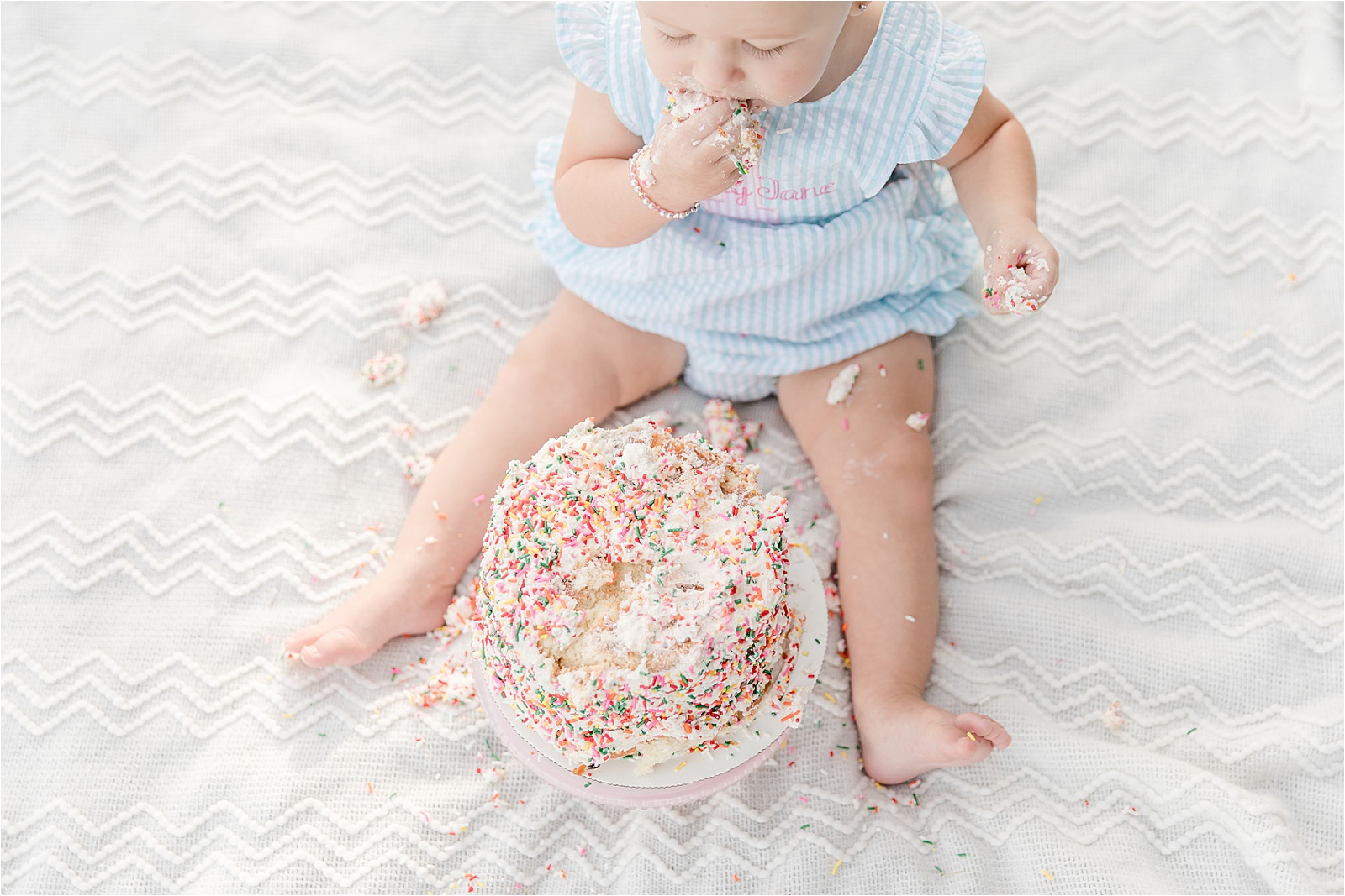 Baby eating smash cake for first birthday by photographer in greenville sc.