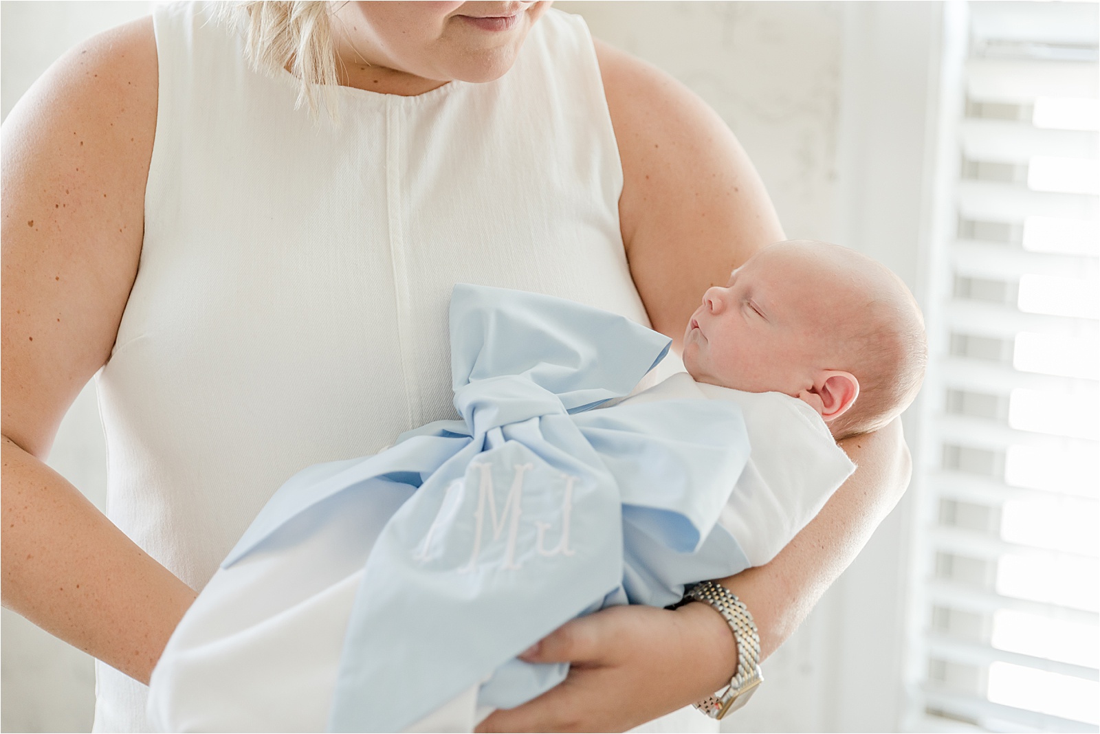 Newborn in bow swaddle in mother's arms