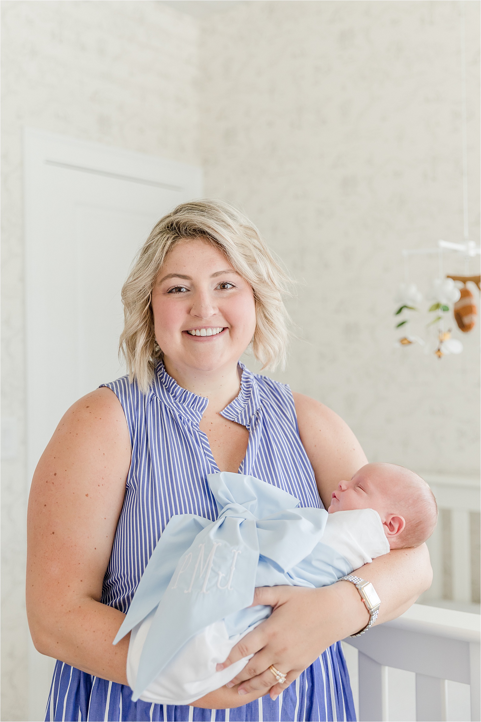Mom holding newborn boy in Beaufort Bonnet Bow Swaddle