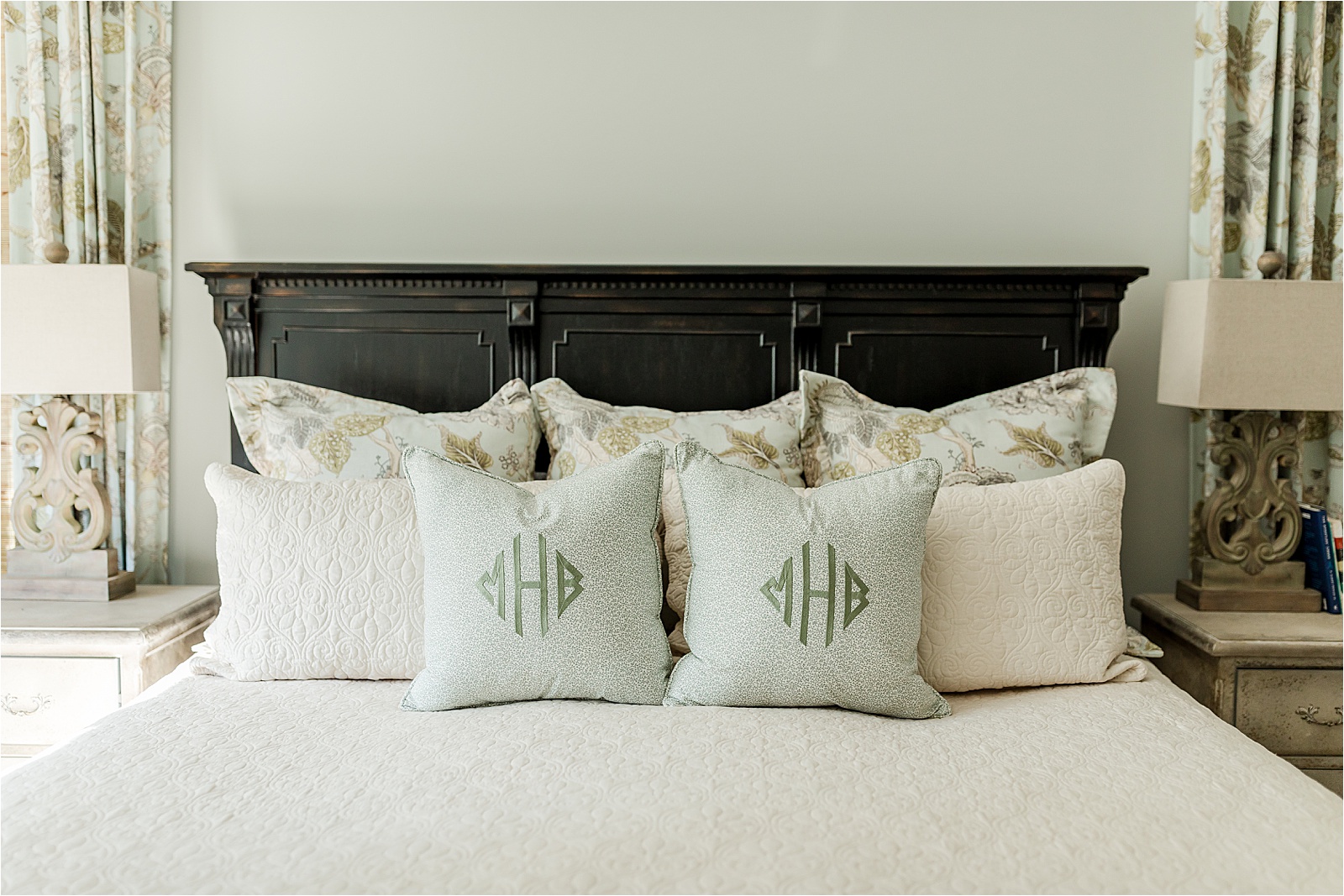 Green and tan bedding on a king size bed with monogrammed pillows