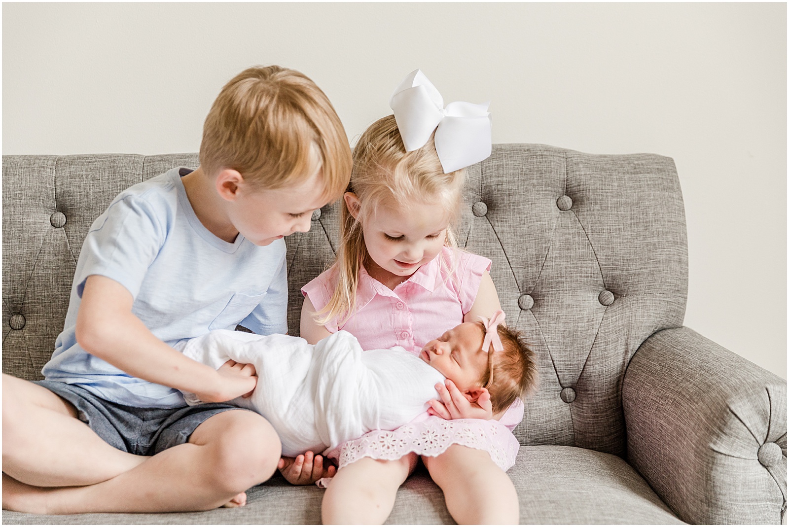 two children holding their baby sister