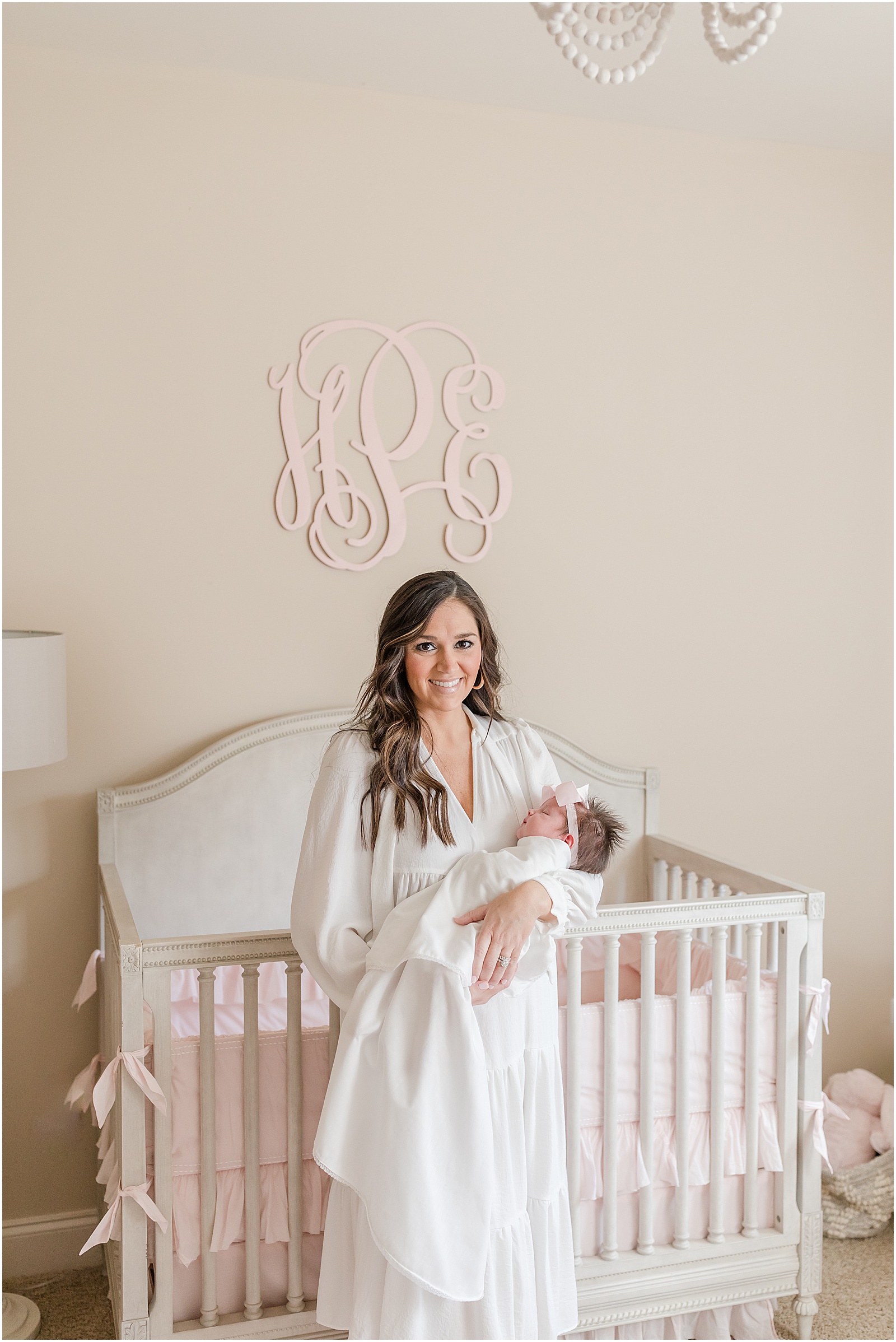 Portrait of a mother in a white dress holding newborn baby girl by Greenville photographer molly hensley