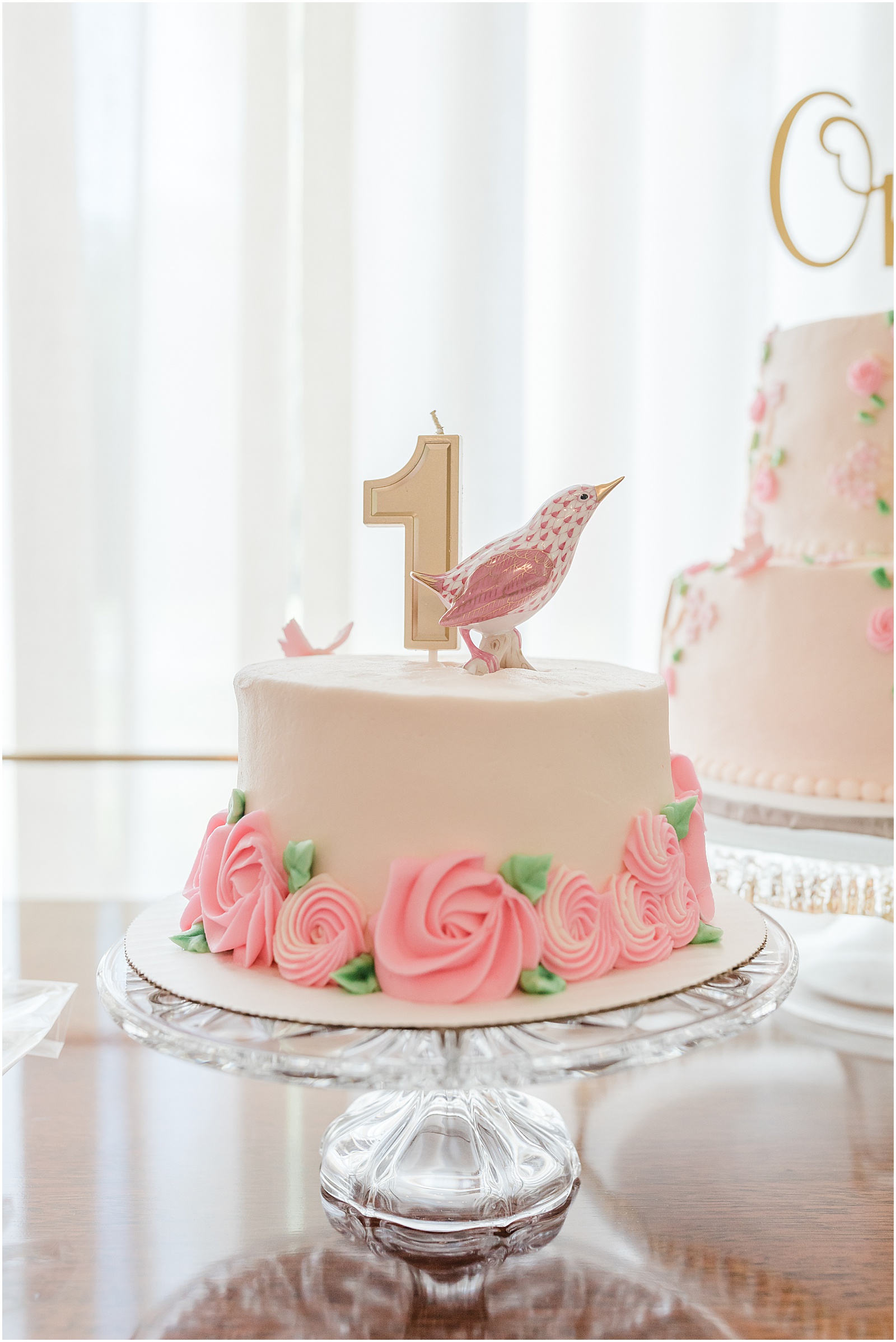 Greenville baby photographer's photos of a smash cake that is pink floral with a Herend cake topper