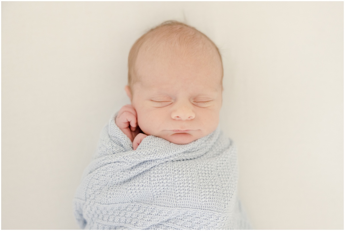 Greenville Newborn Photography of a sleeping newborn baby in blue blanket.