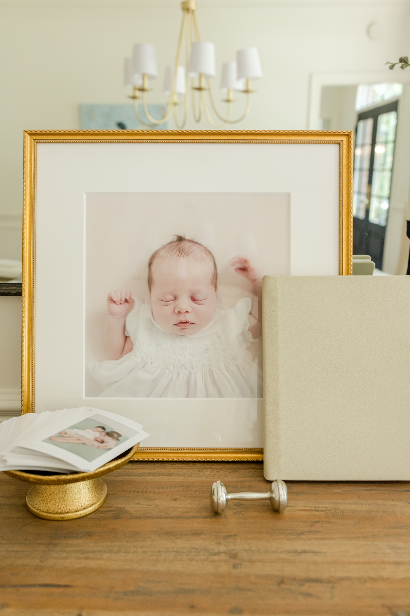 A frame, album, and prints delivered by a Greenville full service newbornphotographer